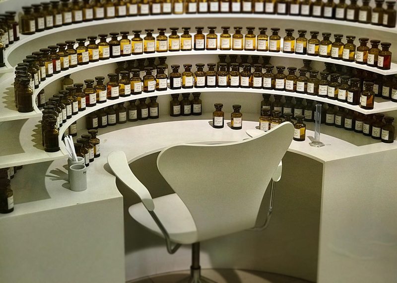 Illustration: A perfume shop with rows of bottles and a white chair