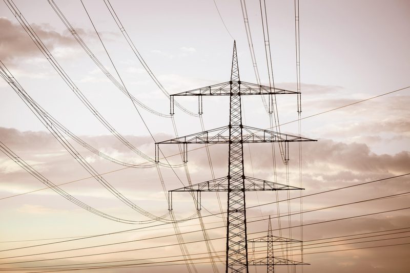 Illustration: High voltage power line pylons against a cloudy sky