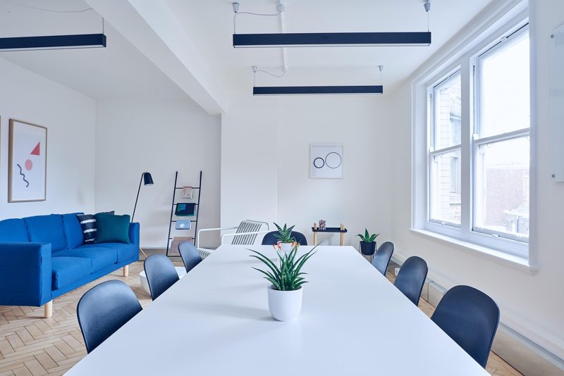 Illustration: A modern meeting room with a large table and blue sofa