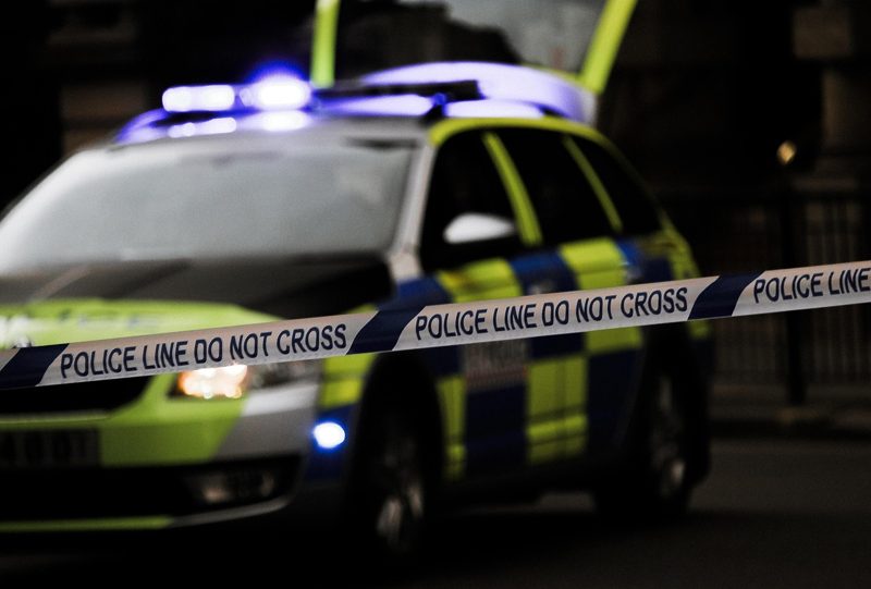 Illustration: A police car behind a police line do not cross tape
