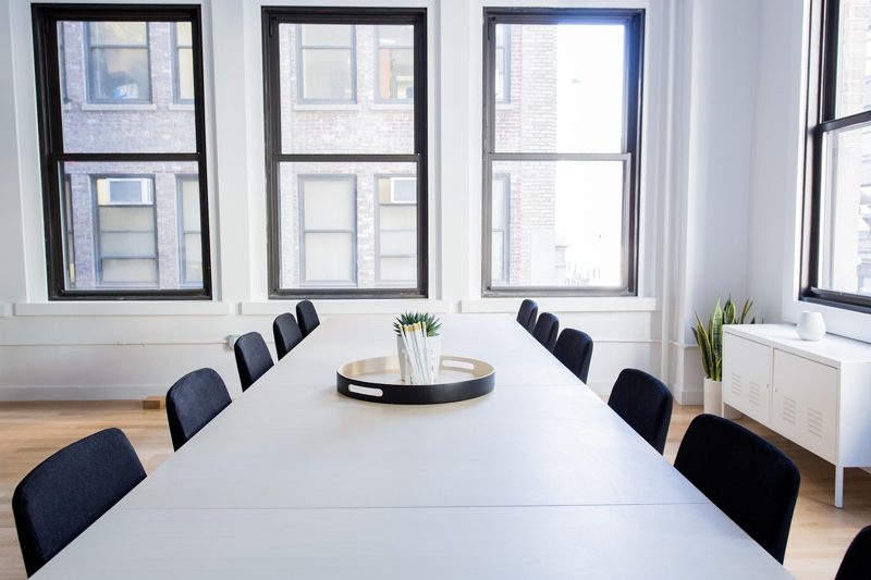 Illustration: A long conference table in a modern office room