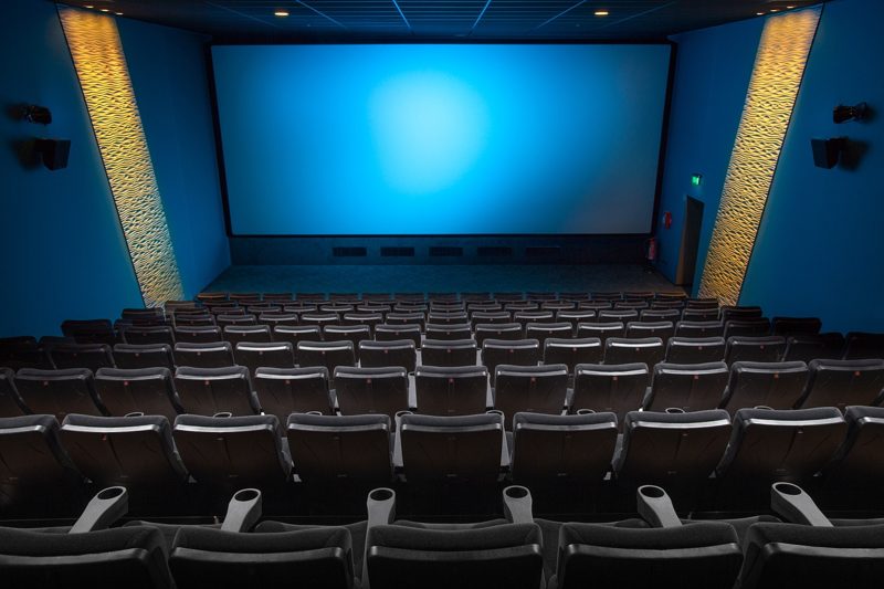 Illustration: Empty seats in a cinema facing a glowing blue screen