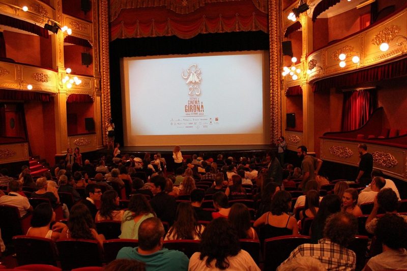 Illustration: An audience watching a film screening inside an ornate theater