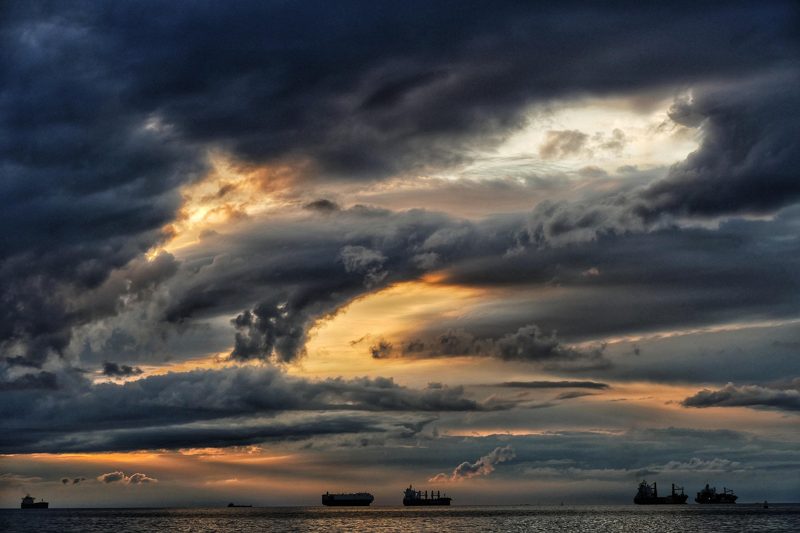 Illustration: Ships on the ocean under dramatic clouds in the sky