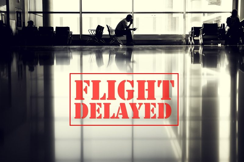 Illustration: An airport terminal with a person sitting and the text "Flight Delayed" overlay