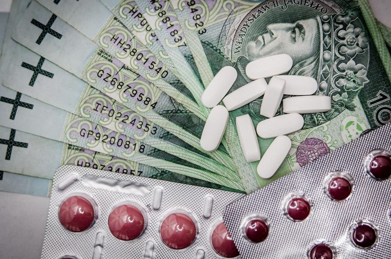 Illustration: Pills and blister packs laid out on banknotes