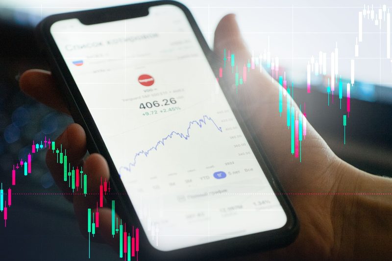 Illustration: A smartphone displaying financial charts and graphs