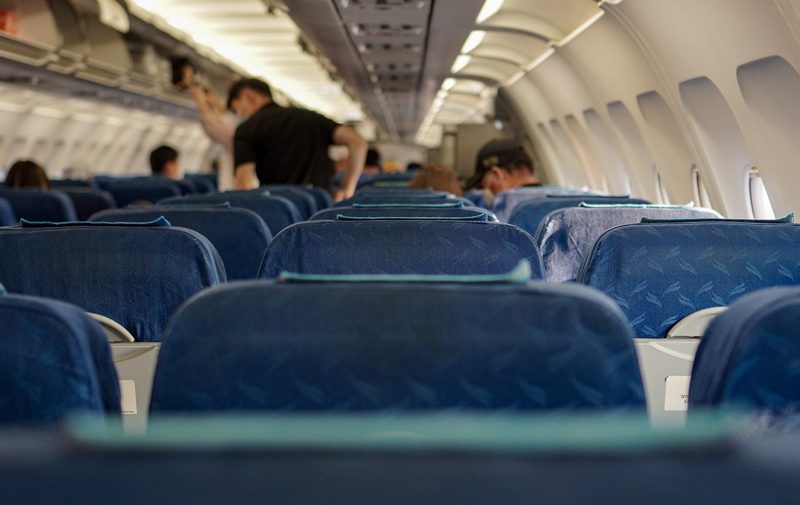 Illustration: The interior of an airplane cabin filled with blue passenger seats