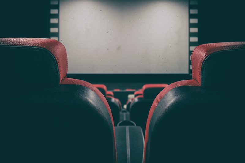 Illustration: Red and black seats in an empty cinema with screen
