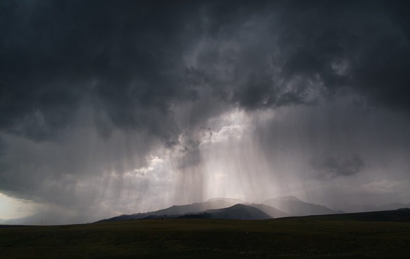 Illustration: A rainy landscape under dark stormy clouds