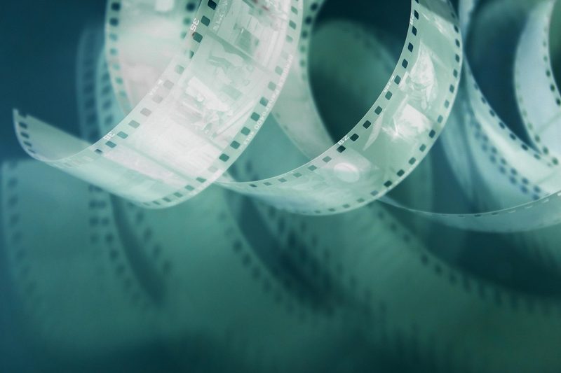 Illustration: Curled film strip with sprocket holes