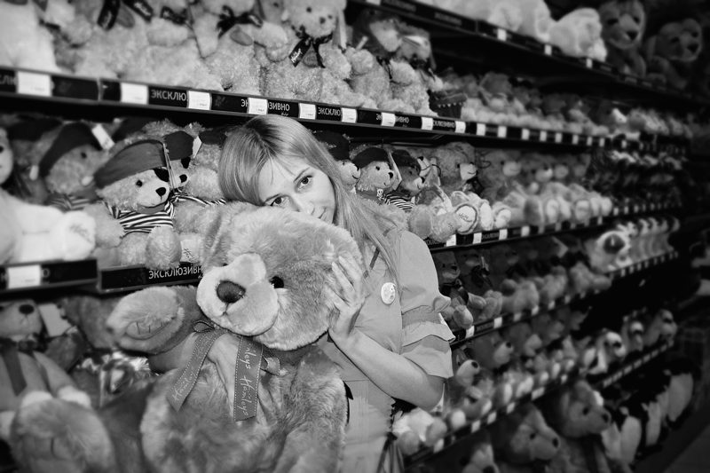Illustration: A woman holding a teddy bear in a toy store