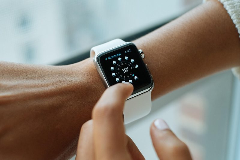 Illustration: A person touching the screen of a smartwatch on their wrist