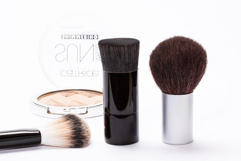 Illustration: Makeup brushes and compact powder on a white surface