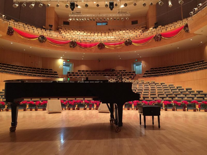 Illustration: A grand piano on a stage in a large auditorium