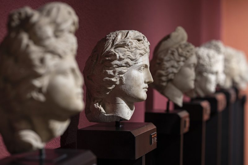 Illustration: A row of ancient stone busts in a museum