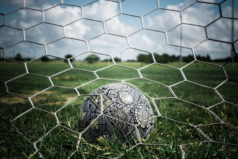 Illustration: A football behind the net in a goal