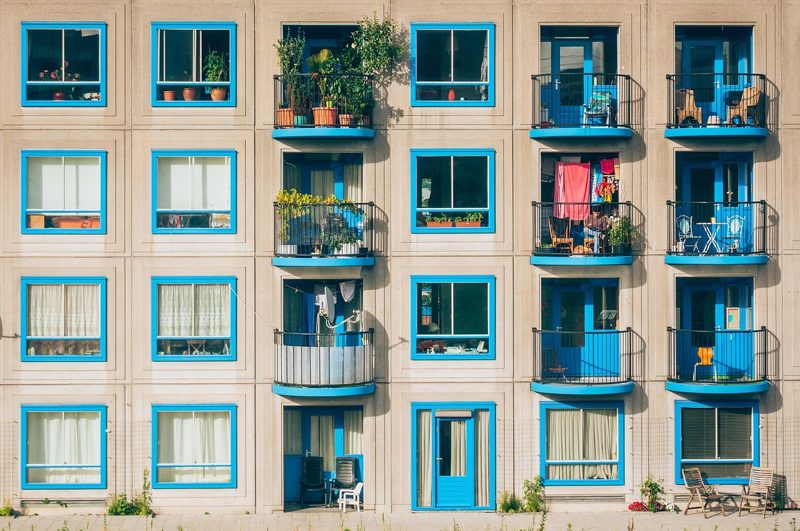 Illustration: The facade of a modern apartment building with blue balconies and windows