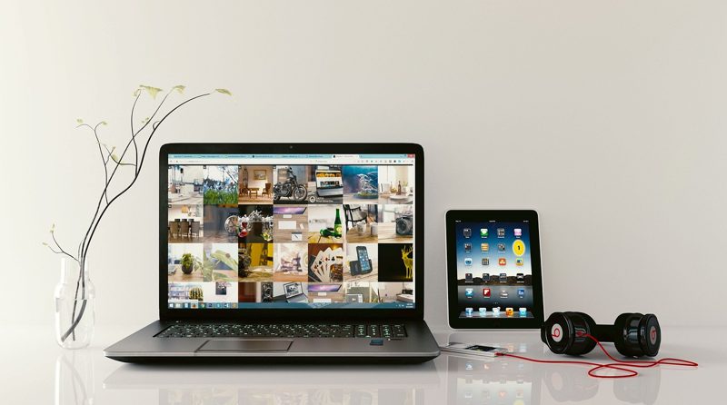 Illustration: A laptop, tablet, headphones and vase on a table