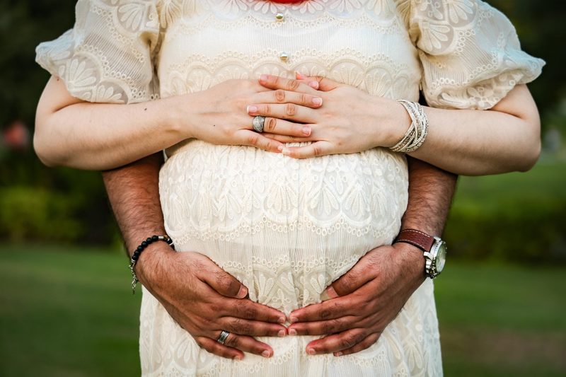 Illustration: A person holding the pregnant belly of another person