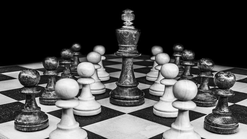 Illustration: A black and white image of chess pieces on board