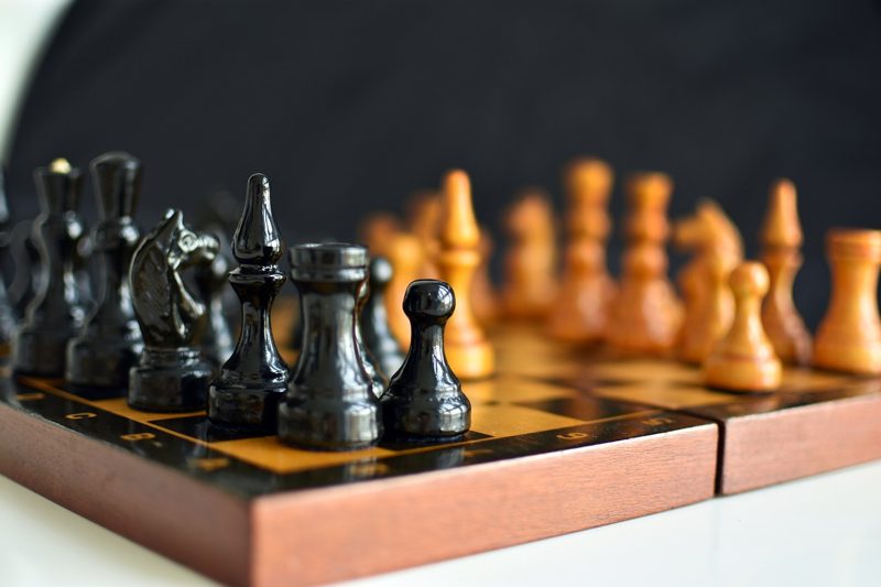 Illustration: A wooden chessboard with black and white chess pieces