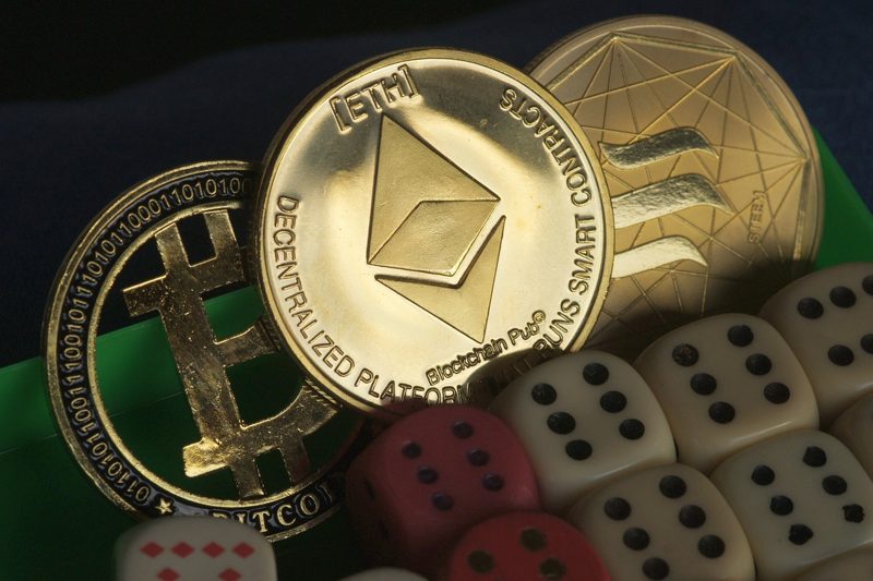 Illustration: Cryptocurrency tokens and dice on a green surface