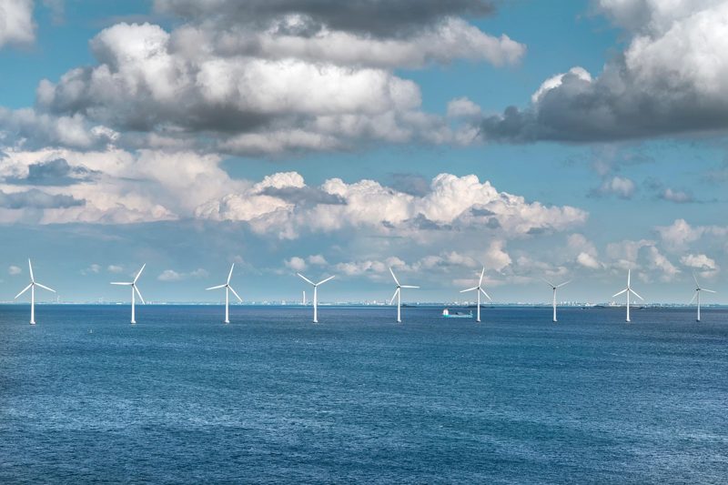 Illustration: A row of offshore wind turbines standing in the sea