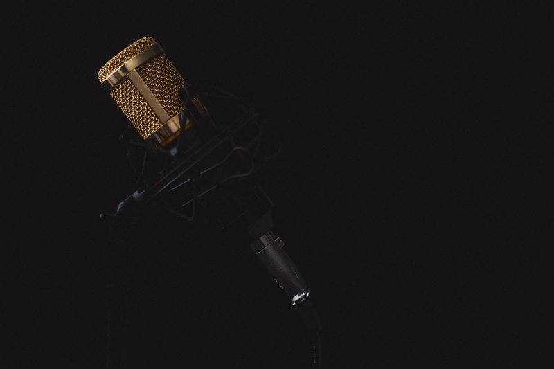Illustration: A golden microphone against a black background