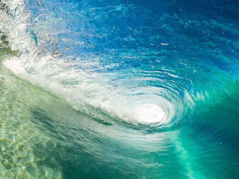 Illustration: An underwater view of a curling blue ocean wave