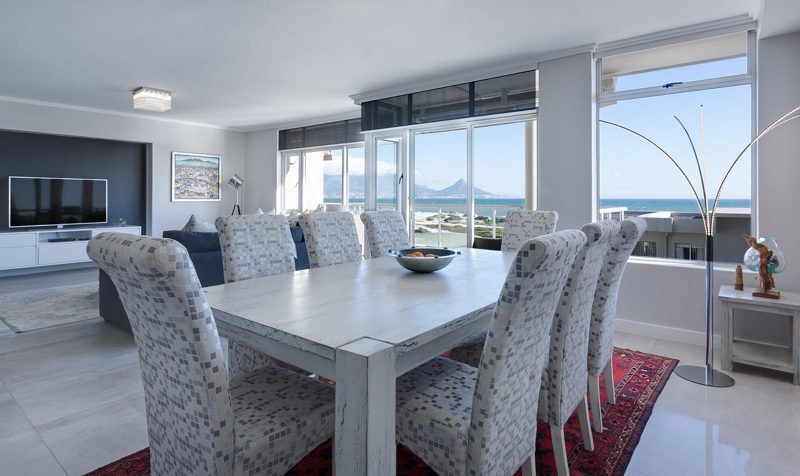 Illustration: A dining table with chairs inside a bright modern apartment