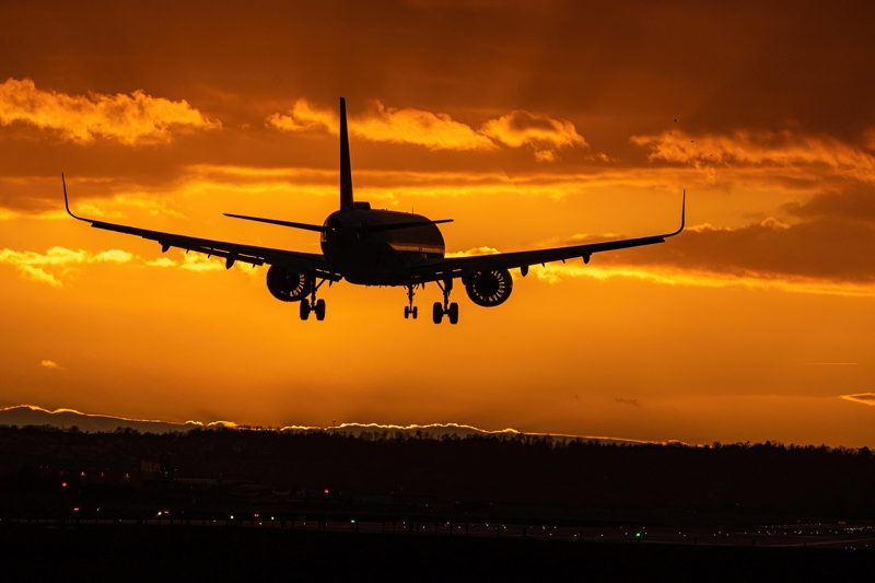 Illustration: An airplane in the sky at sunset