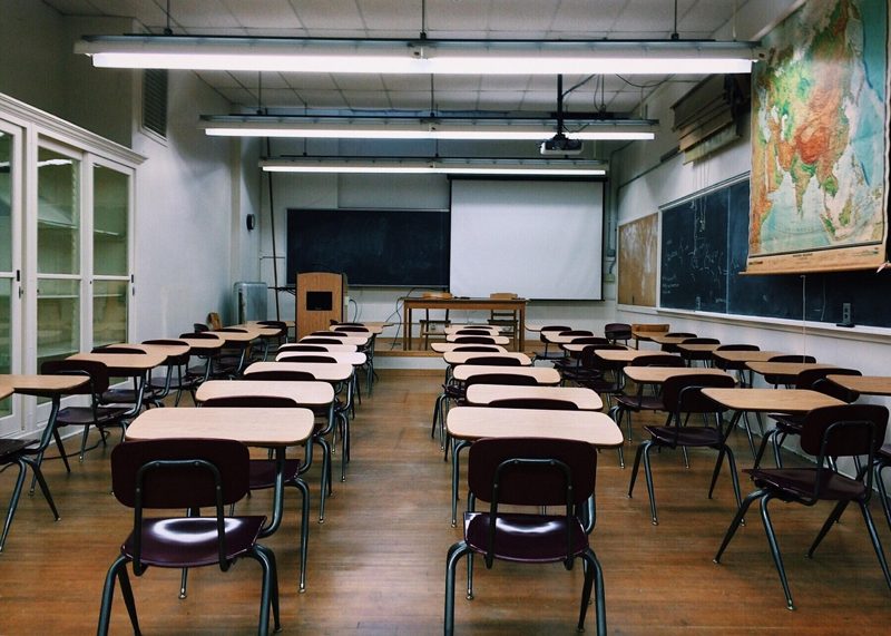 Illustration: An empty classroom with desks and chairs facing a blackboard