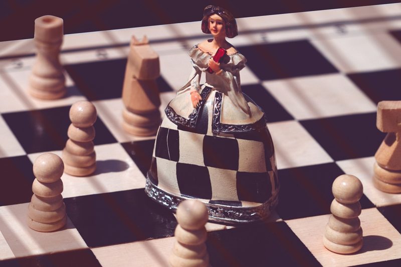 Illustration: A chess piece dressed as a lady on a board