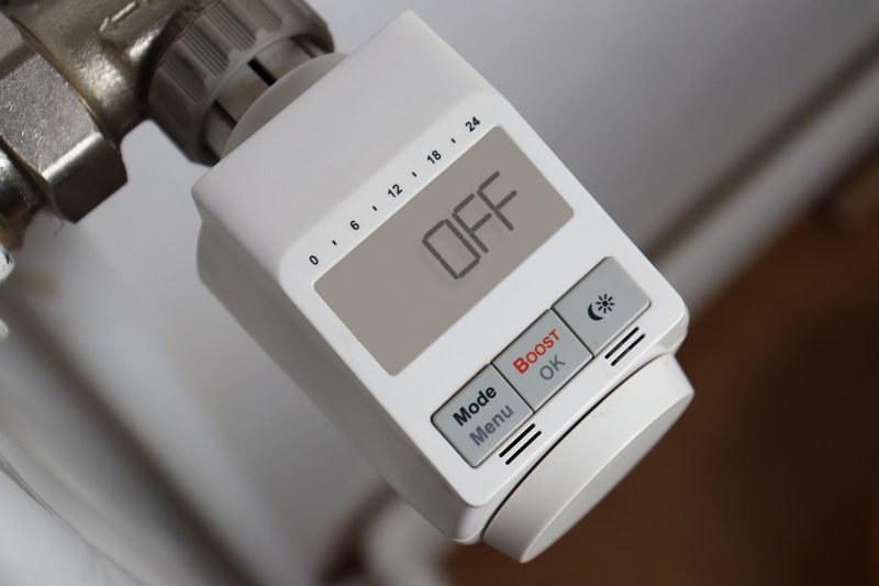 Illustration: A white digital radiator thermostat displaying the word off