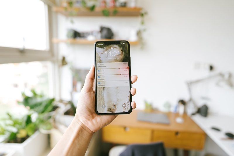 Illustration: A person holding a phone with text messages on screen