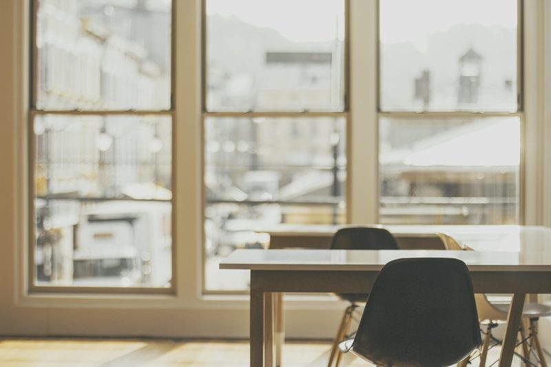 Illustration: An empty desk with chairs next to a window