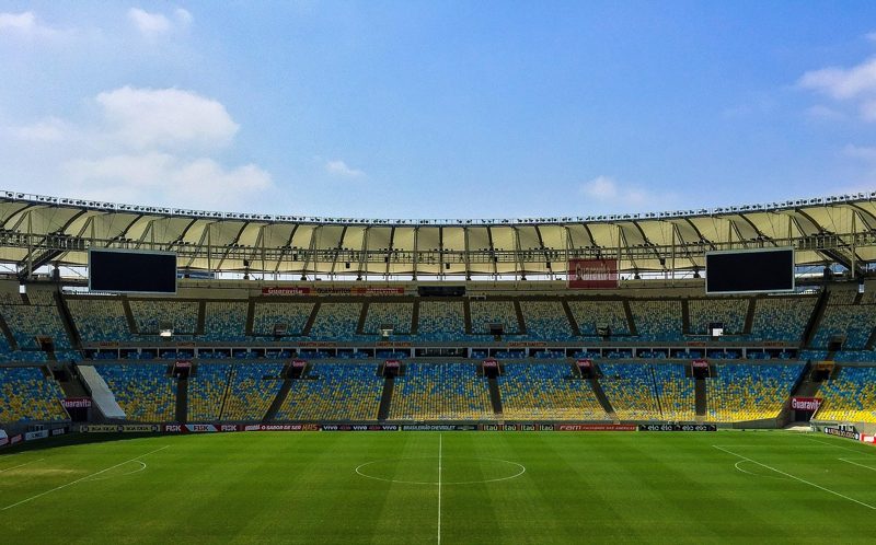 Illustration: An empty football stadium under a blue sky with some clouds