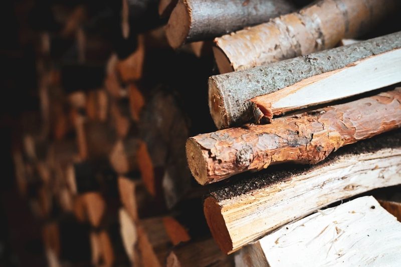 Illustration: Close-up of stacked firewood logs with a dark background