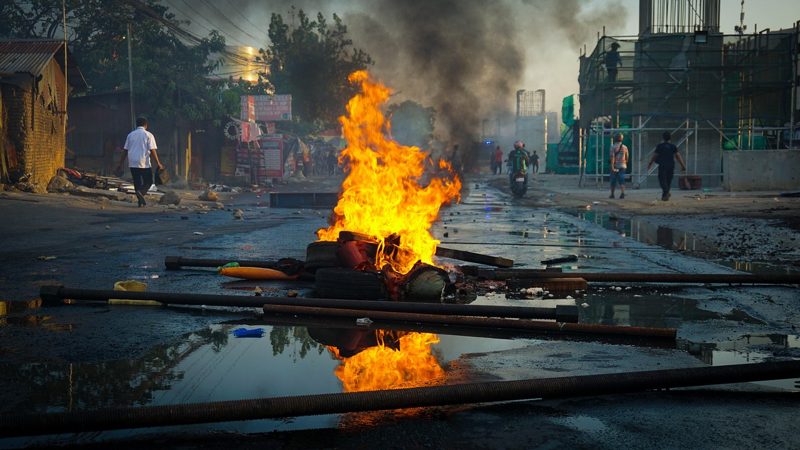 Illustration: A fire burns brightly in the middle of a street