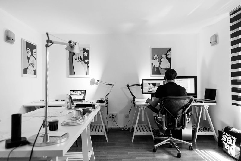 Illustration: A bright office with two desks, computers, and posters