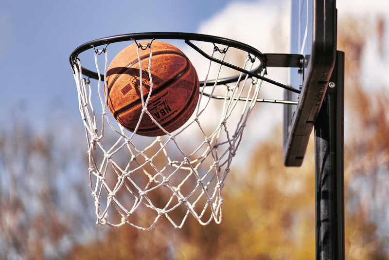 Illustration: A basketball entering a basketball net outdoors