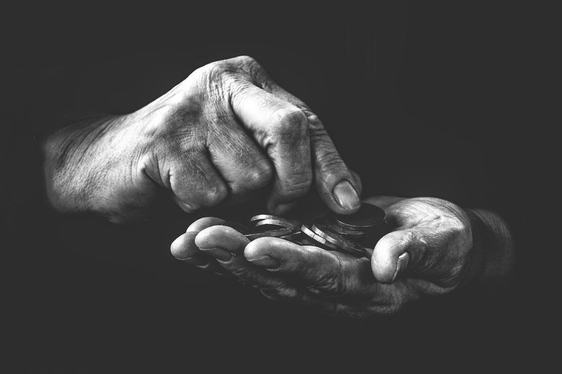 Illustration: A black and white image of hands holding coins