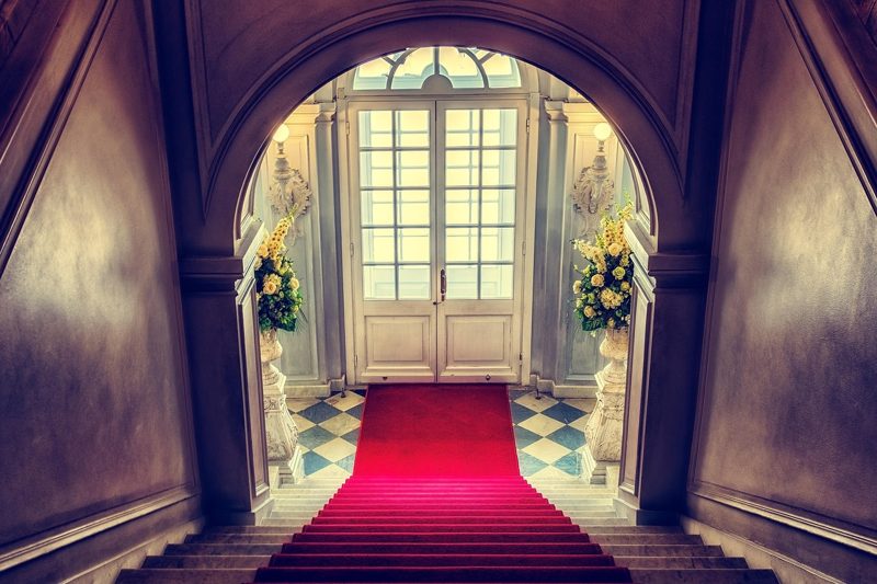 Illustration: A red carpet on stairs leading to white double doors