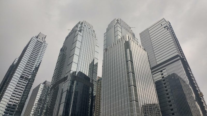 Illustration: Looking up at a group of modern skyscrapers in a city