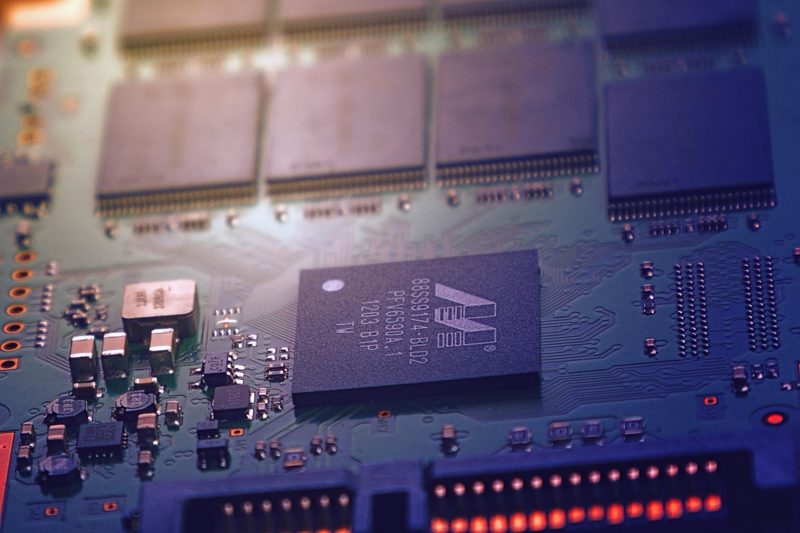 Illustration: A close-up of a circuit board featuring microchips and components