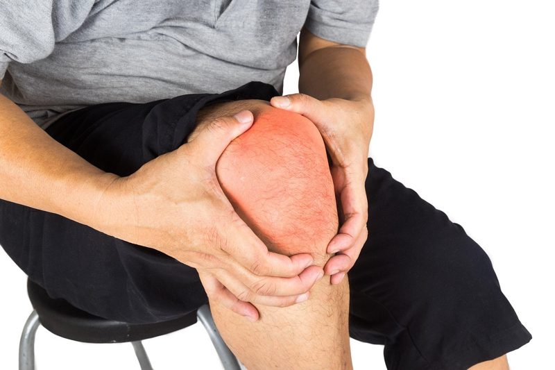 Illustration: A person holding their painful knee with both hands