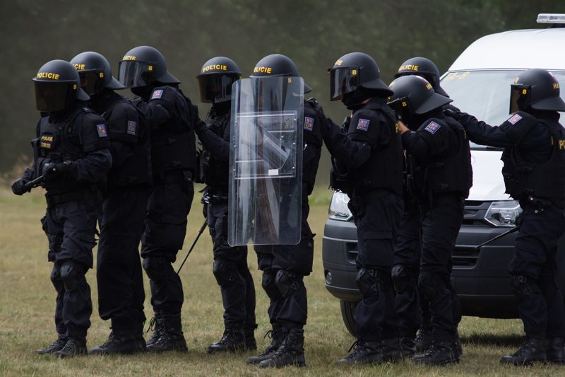 Illustration: A group of riot police officers wearing black uniforms and helmets
